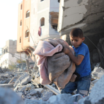 A Gaza un enfant extirpe une couverture d'un immeuble complément détruit - image par Hosny Salah, photographe palestinien résidant actuellement en Palestine, dans la bande de Gaza, pour Pixabay